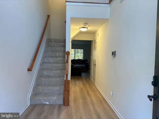 a view of a hallway with wooden floor and staircase