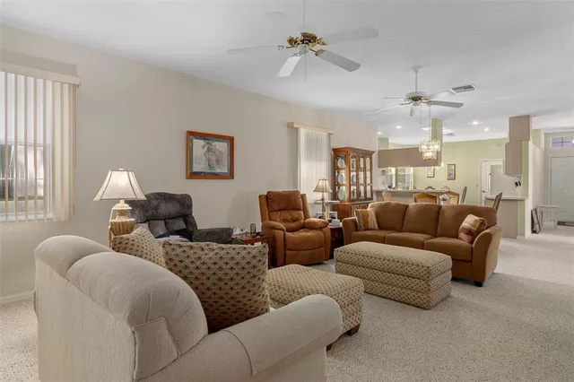 a living room with furniture ceiling fan and a window