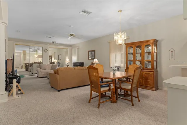 a living room with furniture a chandelier and a dining table