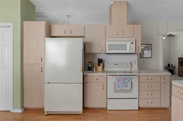 a kitchen with refrigerator a stove a microwave and cabinets