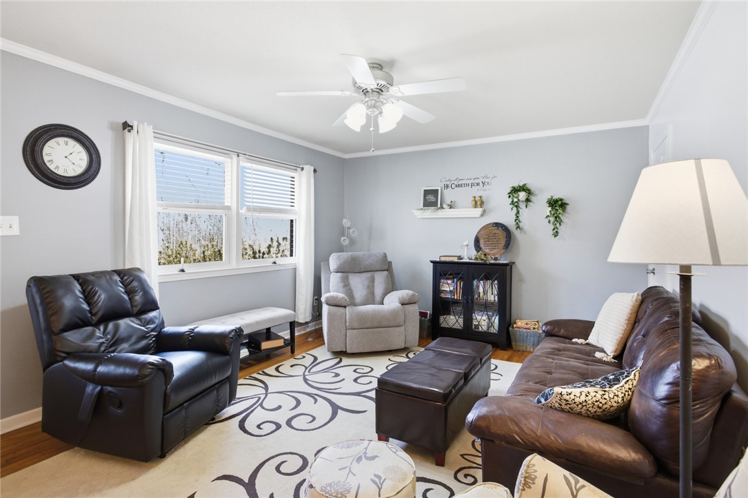 108 Hodge Street Abbeville, SC 29620 - Photo 2 of 39 A comforting living space features a large window, hardwood floors, and a bright ceiling fan.