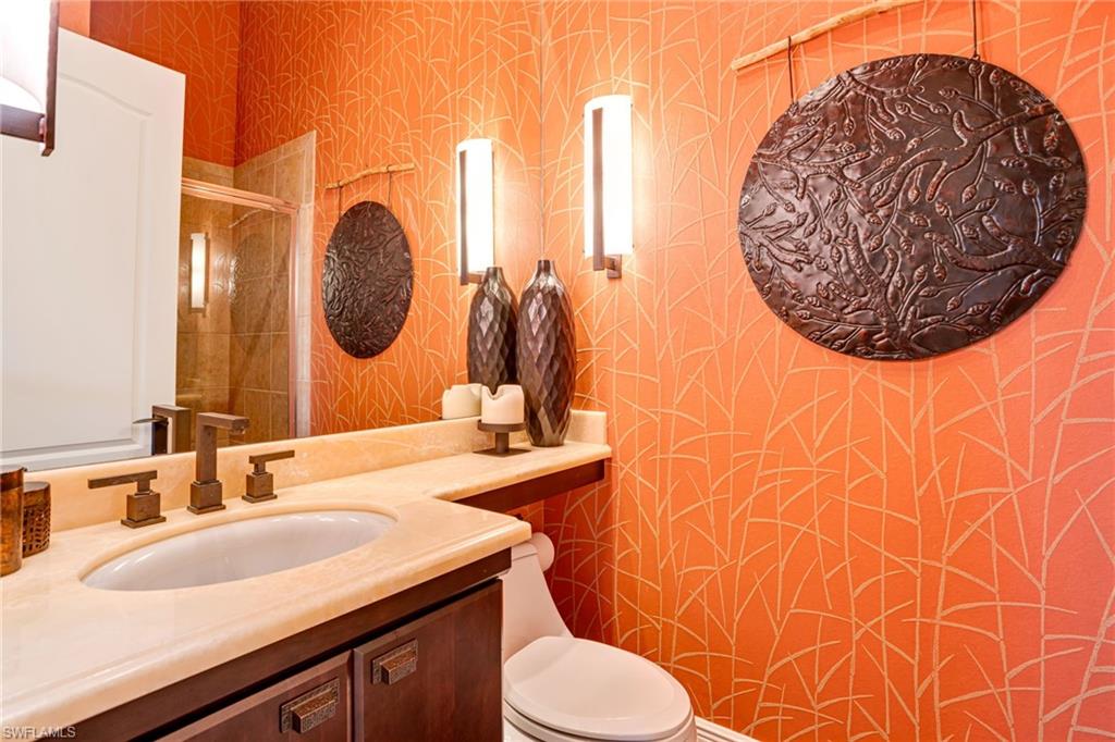 15547 Monterosso Lane, Unit 201 Naples, FL 34110 - Photo 24 of 50 a bathroom with a sink mirror vanity and toilet