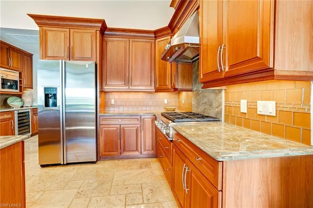a kitchen with stainless steel appliances granite countertop a sink and a refrigerator