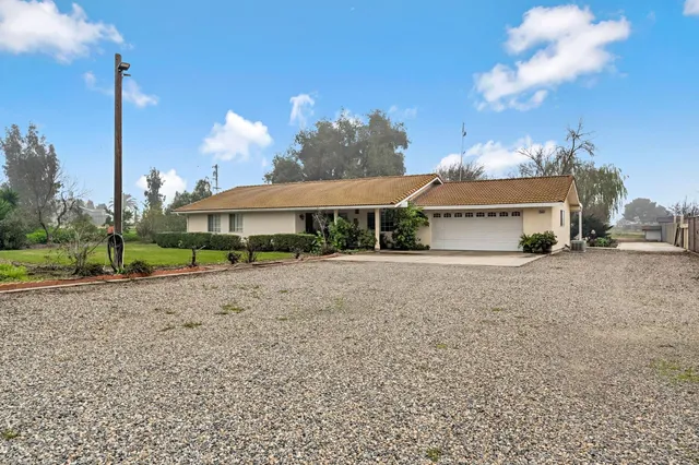a front view of a house with a yard and potted plants