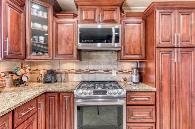 a kitchen with granite countertop a stove top oven cabinetry a sink and dishwasher