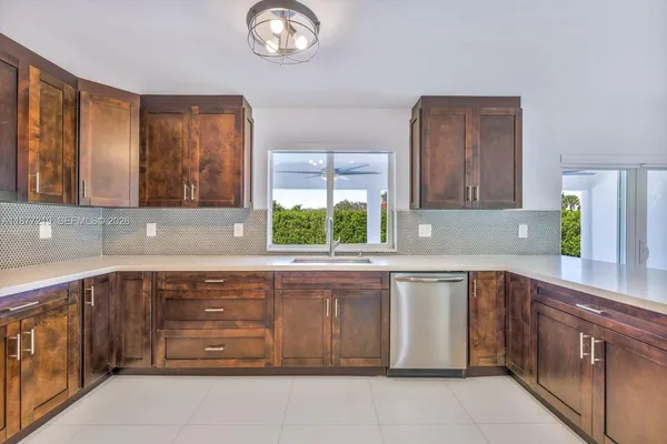a large kitchen with kitchen island a large counter top space a sink stainless steel appliances and cabinets