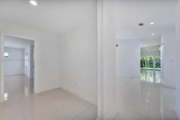 an empty room with a ceiling fan and window