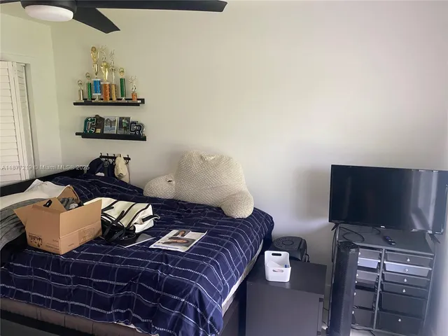 a bedroom with a bed and a flat screen tv