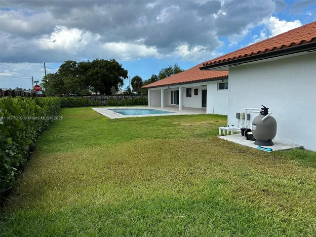 a backyard of a house with table and chairs