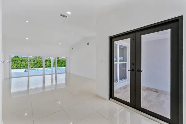 a view of an empty room with wooden floor and a large window