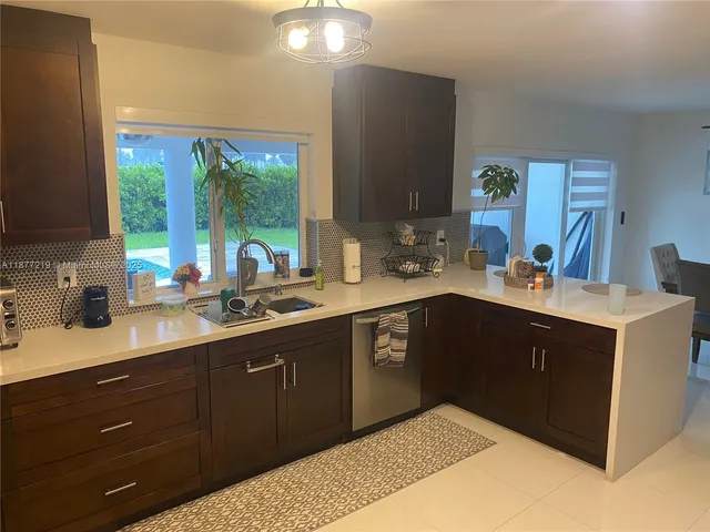 a kitchen with a sink window and cabinets