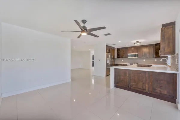 a kitchen with stainless steel appliances granite countertop a refrigerator and a sink
