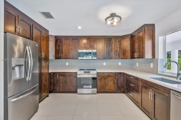 a kitchen with stainless steel appliances granite countertop a stove sink and cabinets