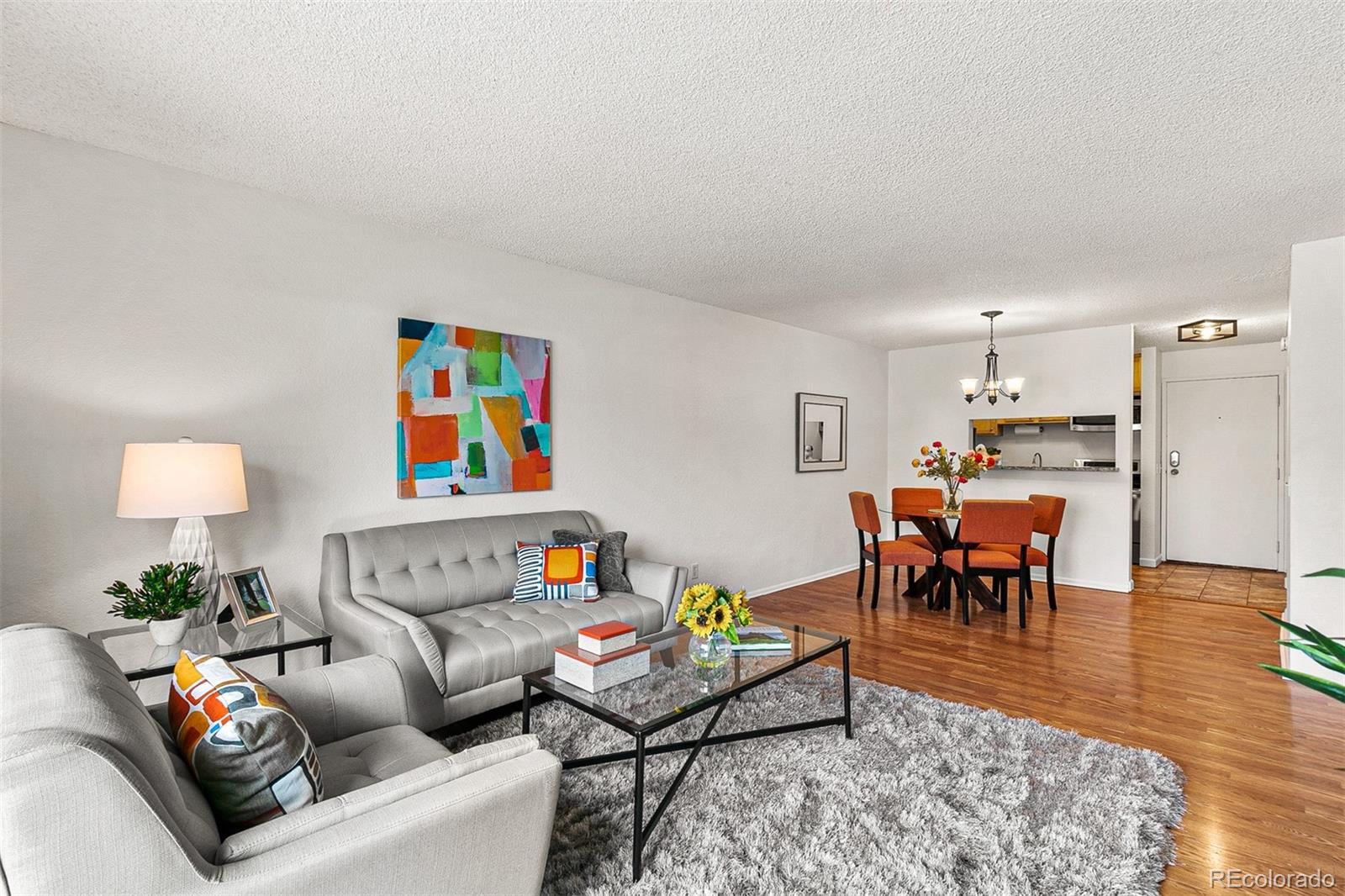 a living room with furniture and a dining table with wooden floor