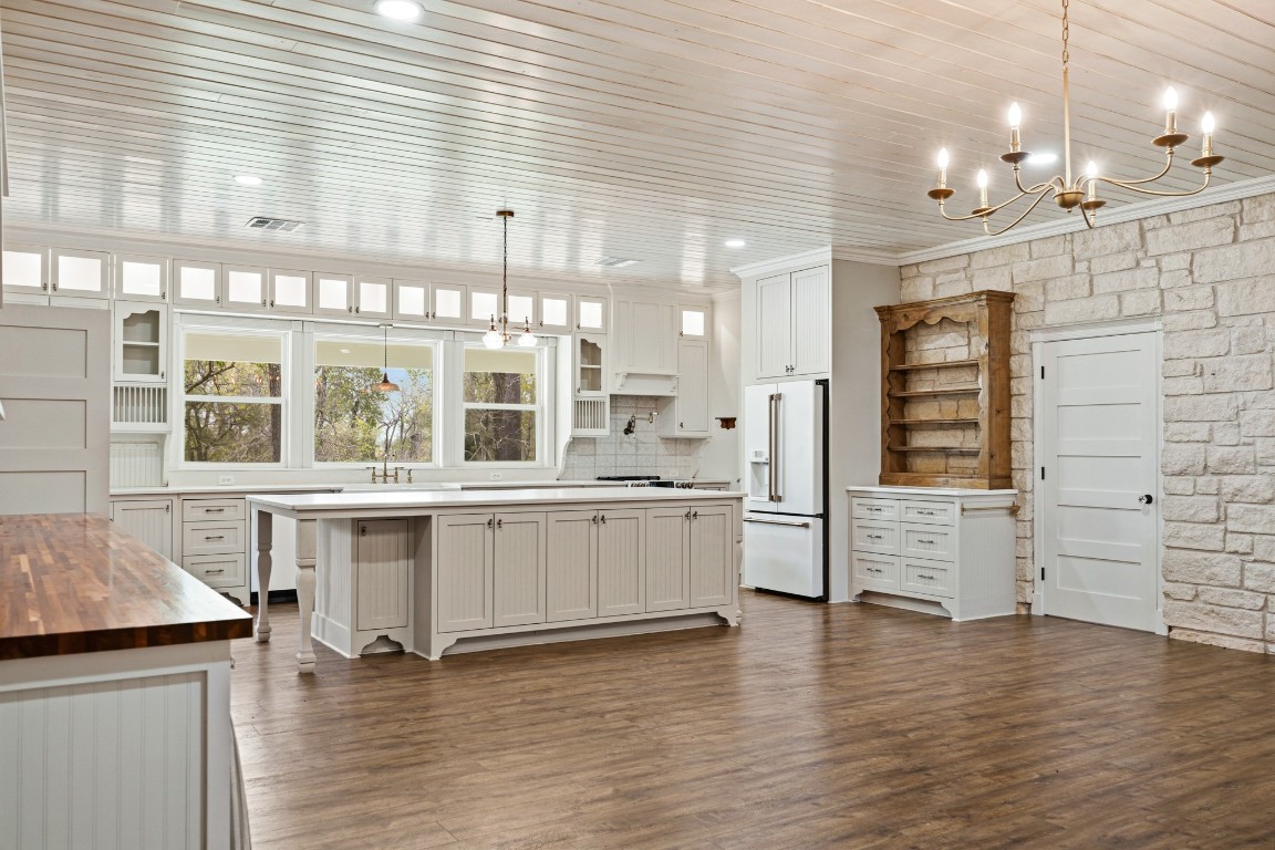41712 Harpers Church Road Hempstead, TX 77445 - Photo 12 of 50 Cottage/Vintage Kitchen, doorway leading to hall to main living area and bathroom, view showing an angle of the large entertaining/eating space wAustin Stone and wood flooring