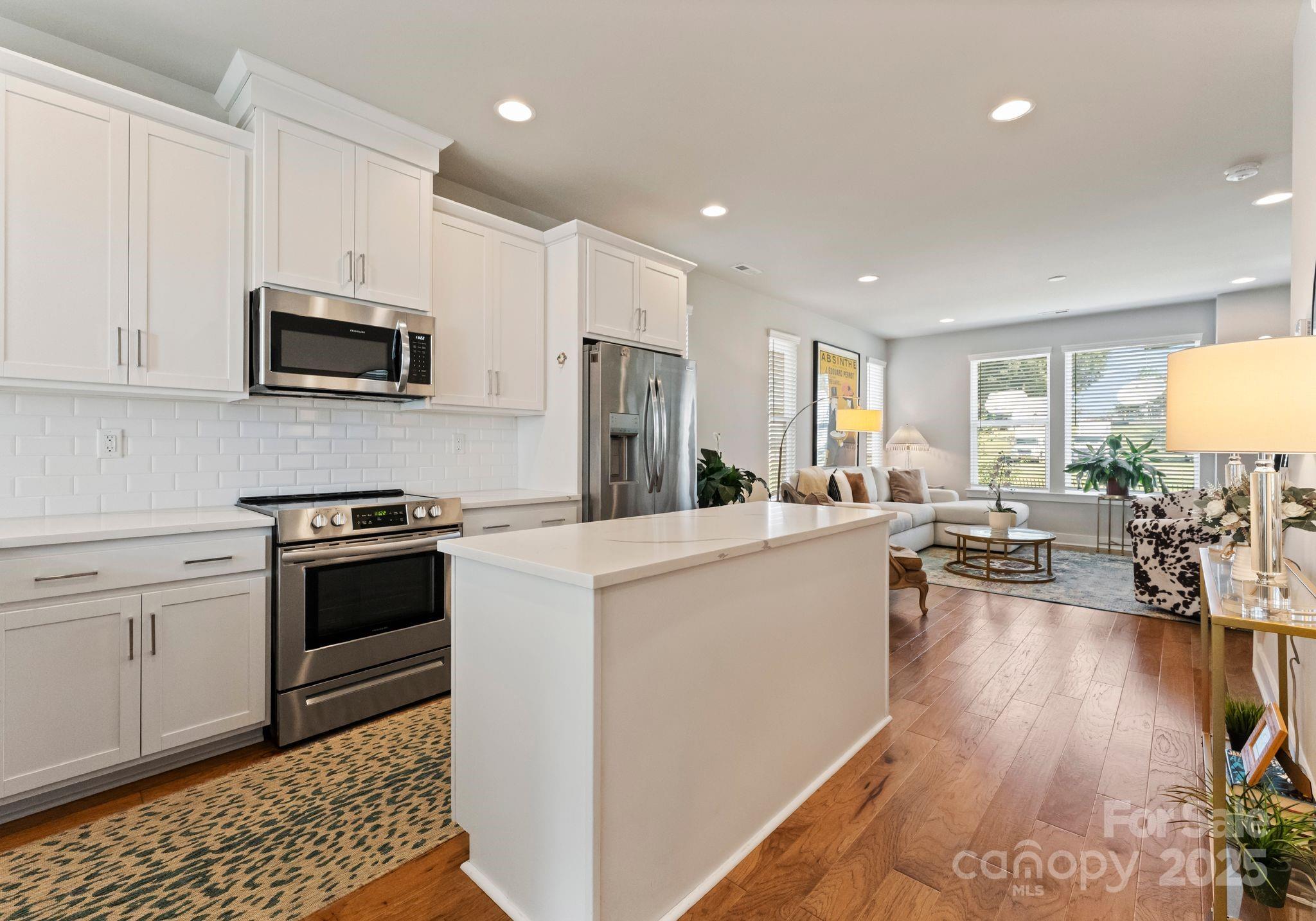 2111 Isom Street Charlotte, NC 28208 - Photo 11 of 36 a kitchen with kitchen island white cabinets and stainless steel appliances