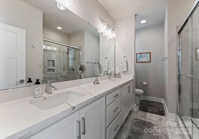 a bathroom with a double vanity sink mirror and toilet
