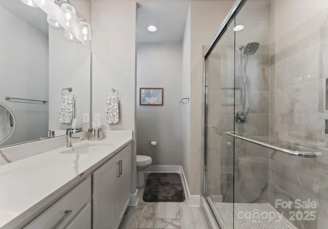 a bathroom with a double vanity sink toilet and shower