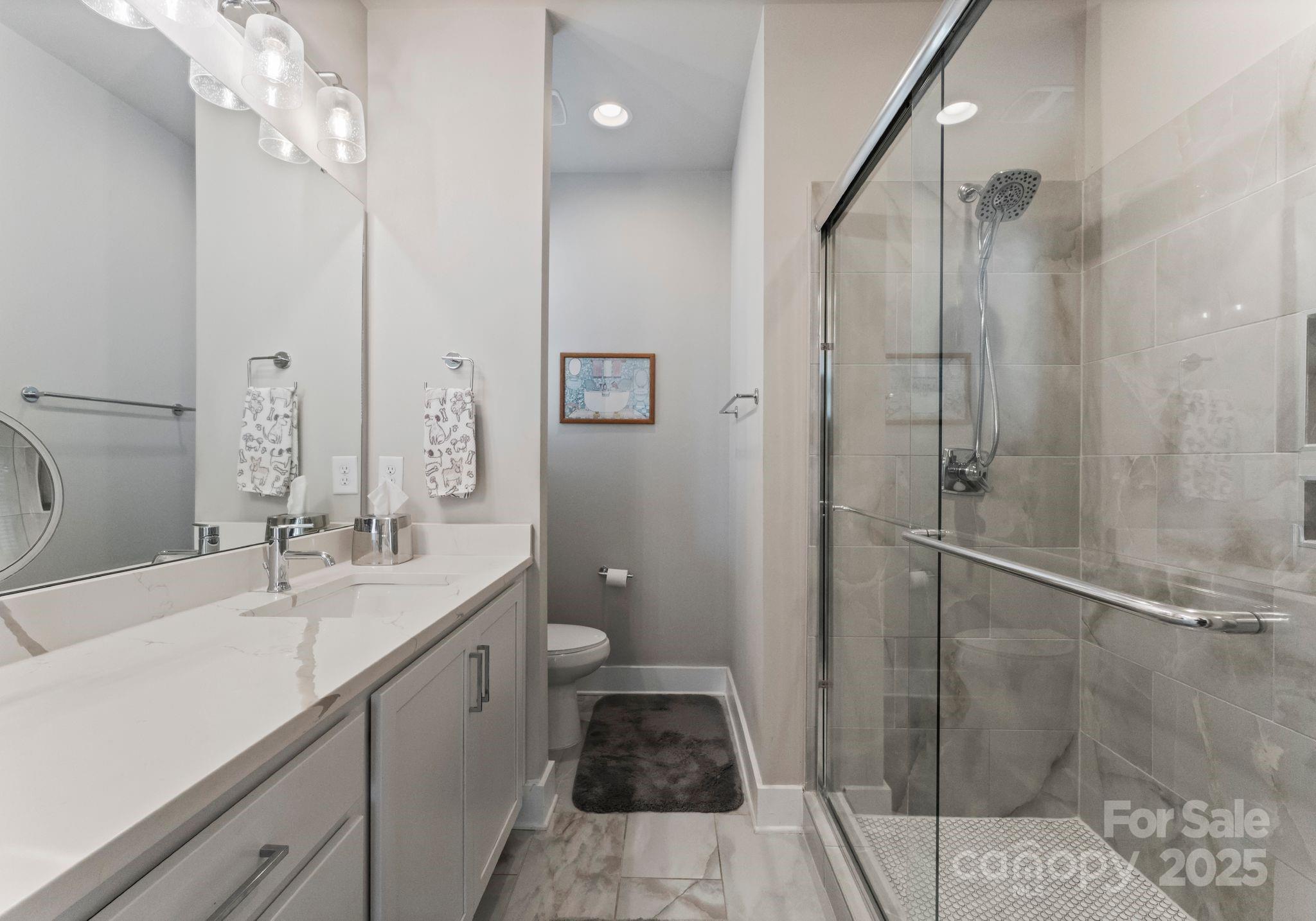 2111 Isom Street Charlotte, NC 28208 - Photo 21 of 36 a bathroom with a double vanity sink toilet and shower