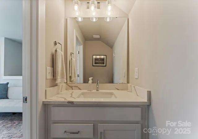 a bathroom with a granite countertop sink and a mirror