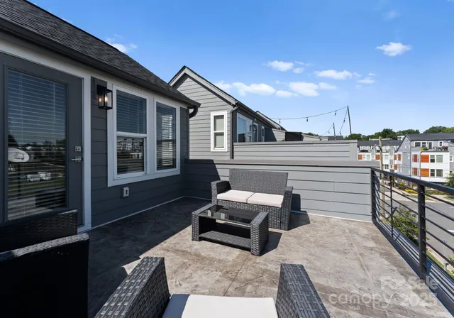 a roof deck with couches and potted plants with sky view