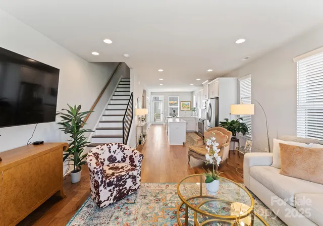 a living room with furniture a flat screen tv and a potted plant