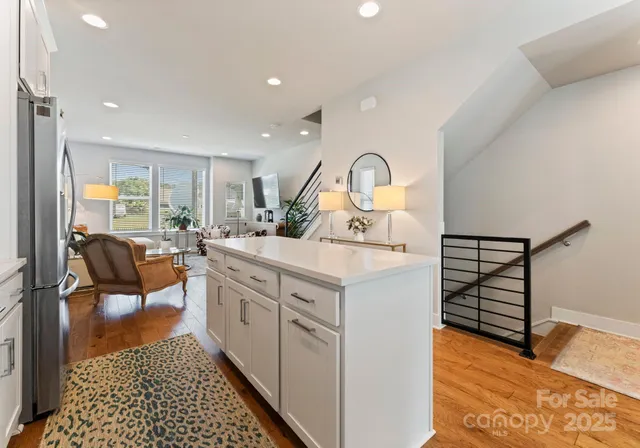 a kitchen with sink refrigerator and view of living room