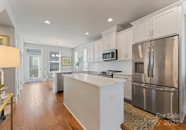 a kitchen with stainless steel appliances a refrigerator sink and microwave