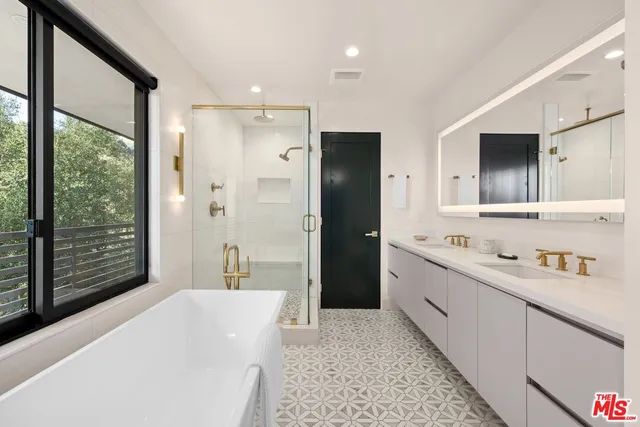 a bathroom with a tub sink and mirror