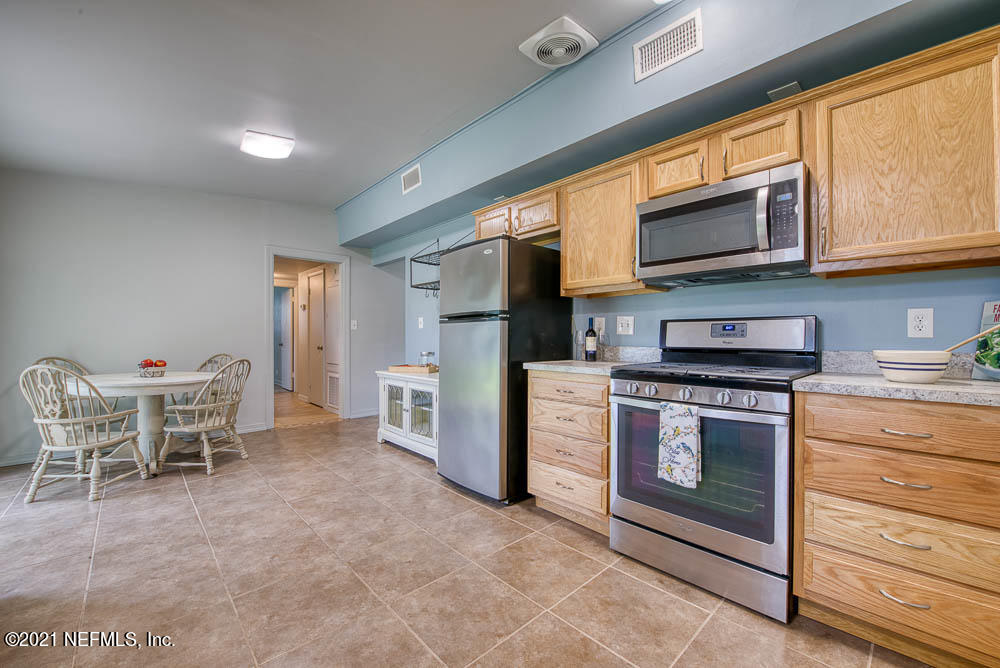 7542 Proxima Road Jacksonville, FL 32210 - Photo 6 of 14 a kitchen with stainless steel appliances granite countertop a stove top oven a refrigerator and a microwave