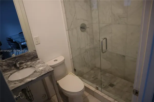 a bathroom with a sink a toilet and a shower