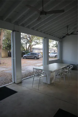 a living room with patio furniture and a floor to ceiling window