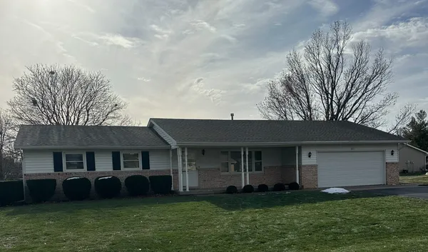 a view of a yard in front of a house with large windows