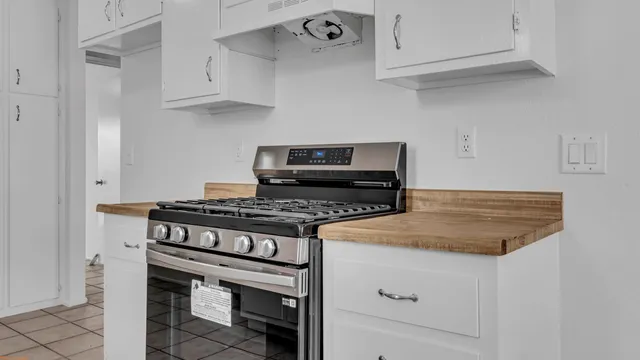 a stove top oven sitting inside of a kitchen