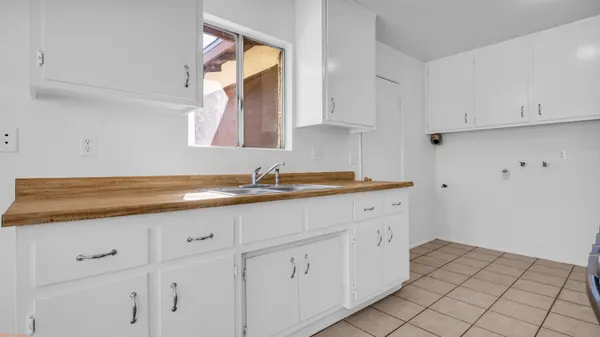 a kitchen with white cabinets and sink