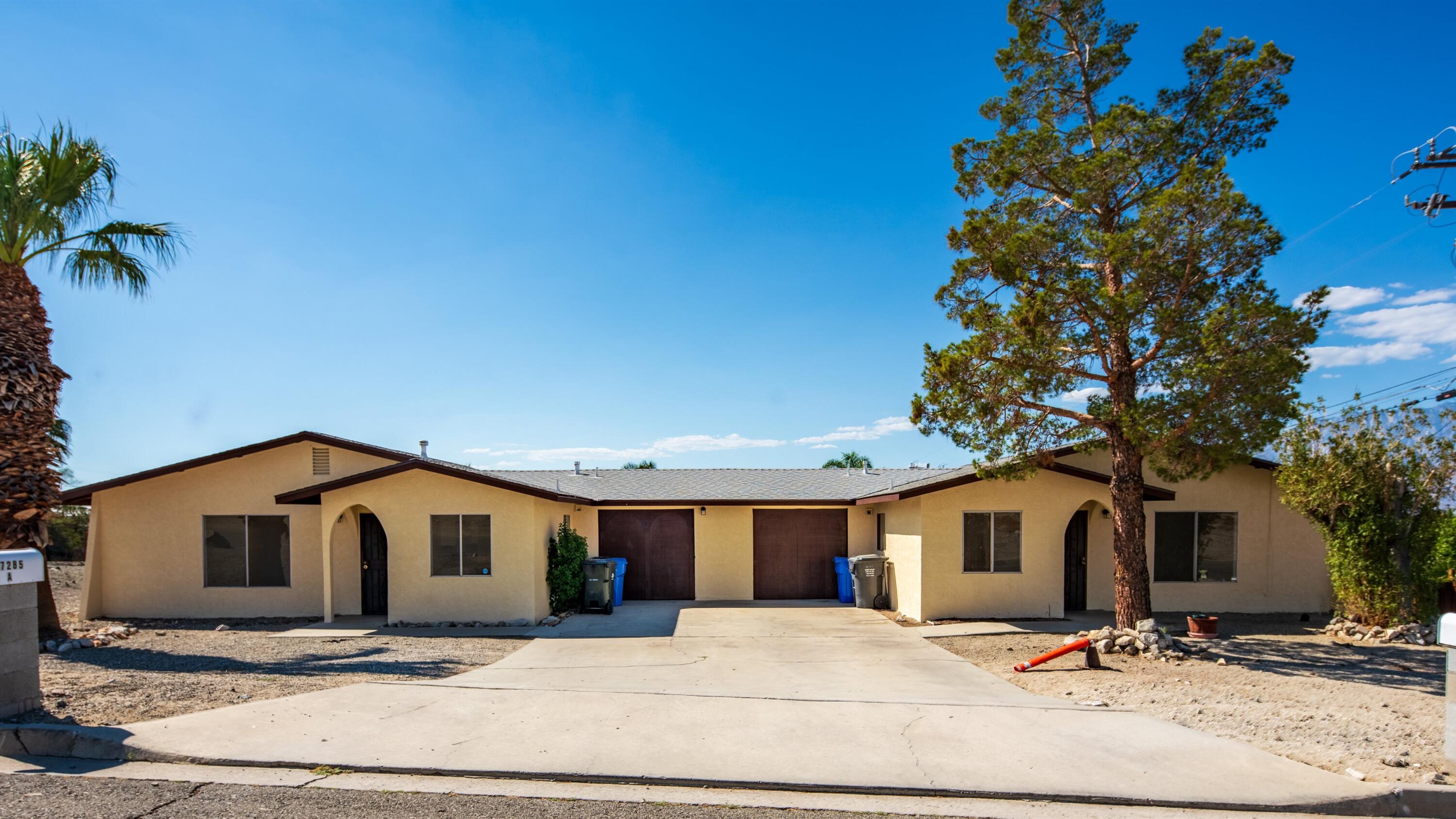 67285 Pierson Boulevard, Unit B Desert Hot Springs, CA 92240 - Photo 2 of 29 a large white house with a large tree in front of it