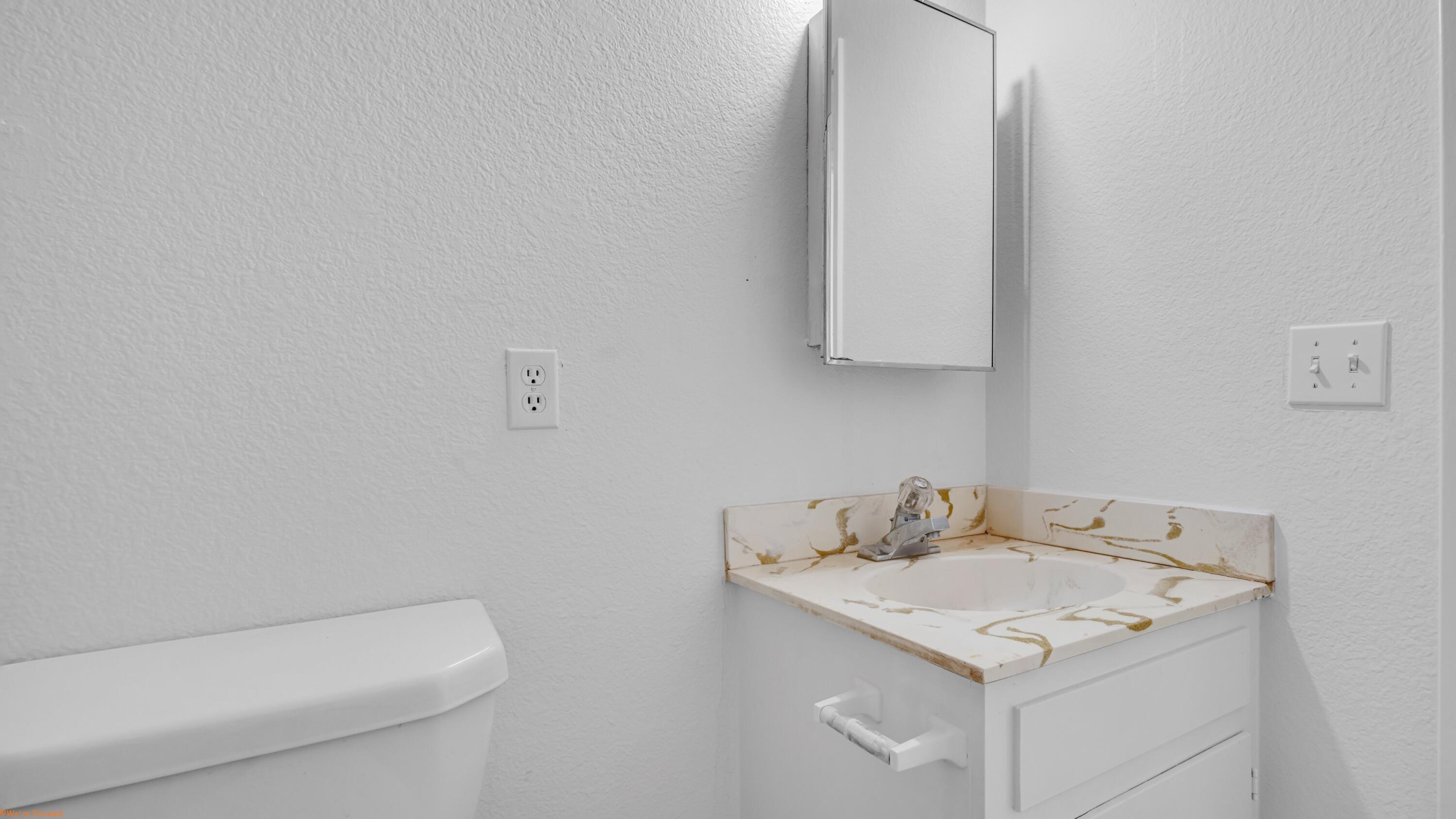 67285 Pierson Boulevard, Unit B Desert Hot Springs, CA 92240 - Photo 24 of 29 a bathroom with a sink a toilet and mirror