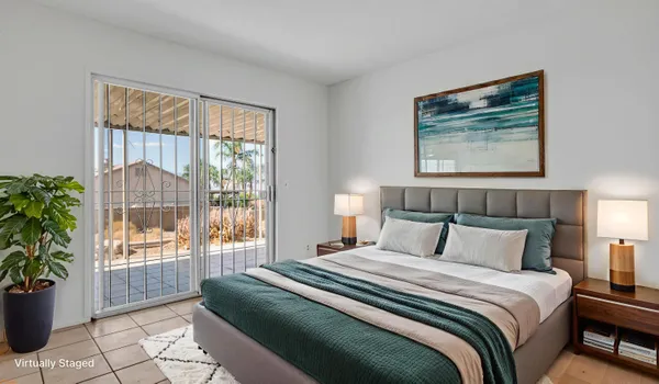 a bedroom with a large bed and a potted plant