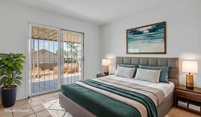 a bedroom with a large bed and a potted plant