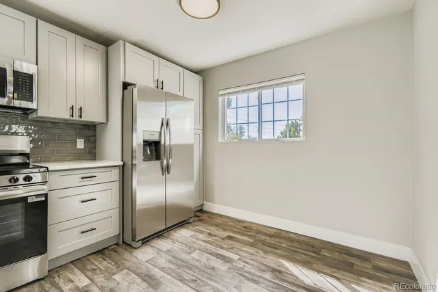 a kitchen with granite countertop a refrigerator stove and microwave