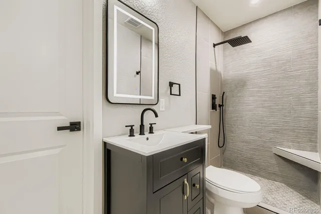 a bathroom with a toilet a sink and mirror