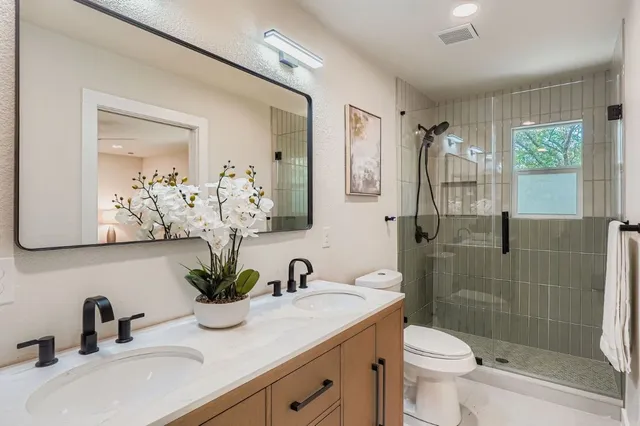 a bathroom with a sink a toilet and shower