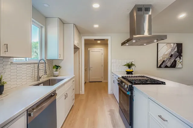 a kitchen with stainless steel appliances granite countertop a sink stove and refrigerator