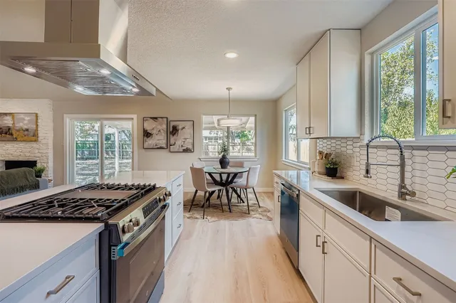 a kitchen with stainless steel appliances granite countertop a stove a sink dishwasher and a refrigerator