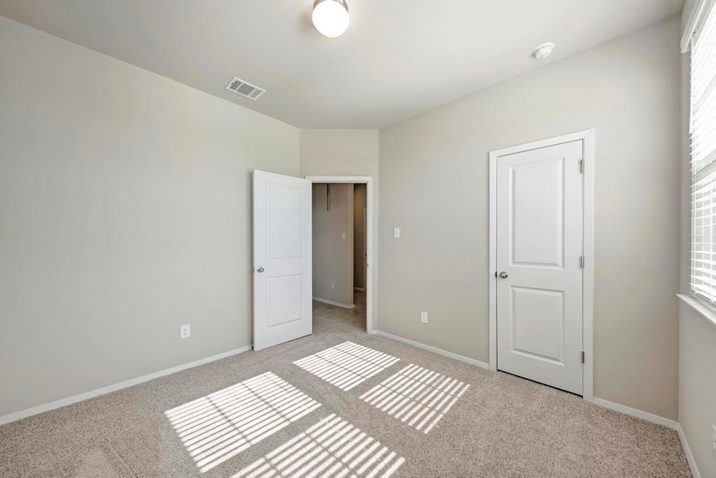 1209 Goforth Road Kyle, TX 78640 - Photo 23 of 32 Sun-drenched, well-lit bedroom features ample floor space and a convenient walk-in closet.