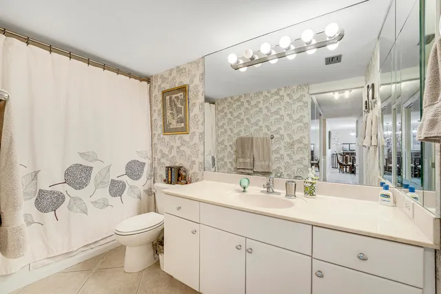 a bathroom with a double vanity sink mirror and toilet