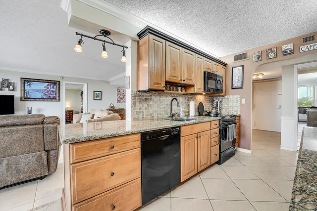 a large kitchen with stainless steel appliances granite countertop a sink and cabinets