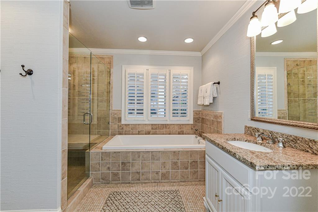 2700 Normandy Road Charlotte, NC 28209 - Photo 27 of 42 a bathroom with a granite countertop sink a large mirror and a shower