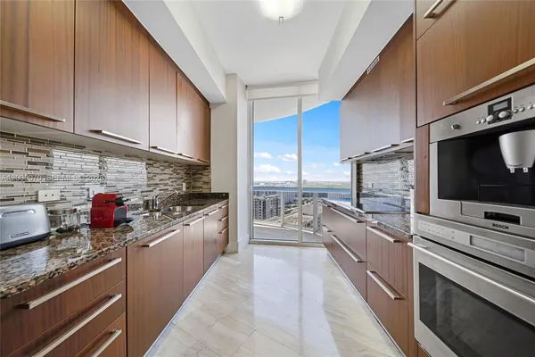 a kitchen with stainless steel appliances kitchen island granite countertop a stove and a sink