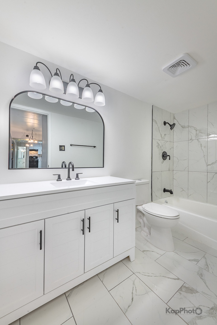 669 Chappel Avenue, Unit 1A Calumet City, IL 60409 - Photo 22 of 24 a bathroom with a sink mirror and a bathtub